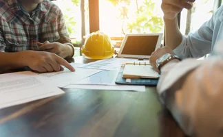 Engineers discussing papers Engineers discussing papers